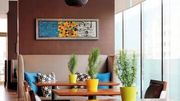 A modern interior with seating, tables, and potted plants.
