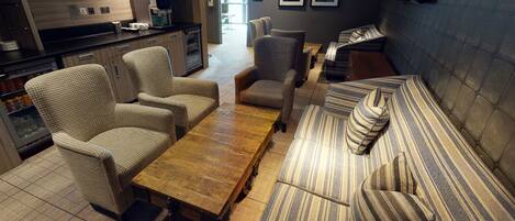 A modern living room with a wooden coffee table, striped sofa, and wicker chairs.