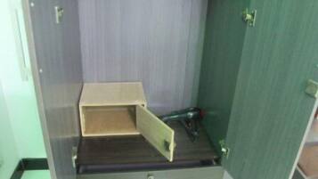 Una habitació amb un armari de fusta, una taula petita i una paret verda.