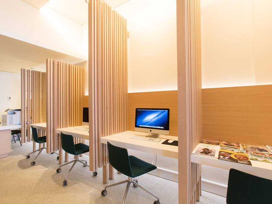 A modern office space with desks, chairs, and a computer monitor.