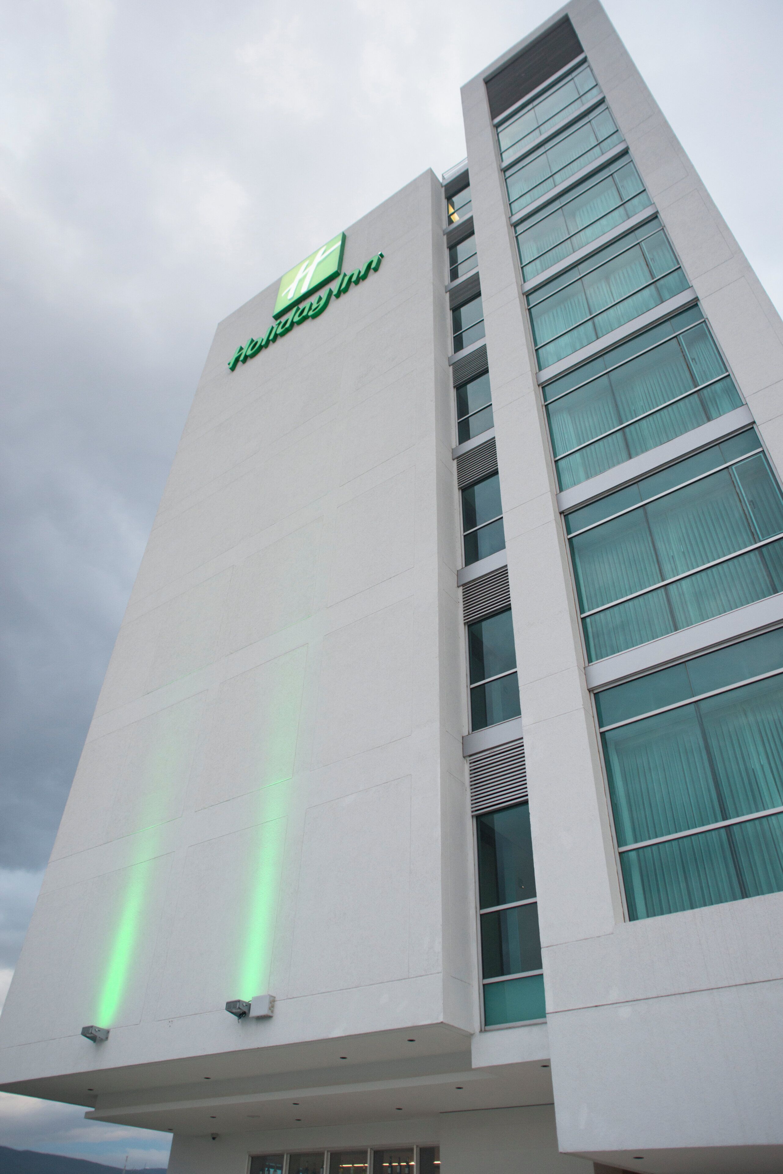 A tall building with a prominent 'Holiday Inn' sign at the top.