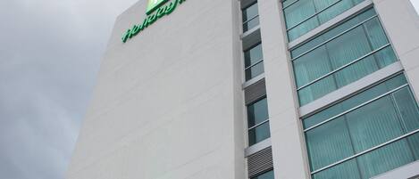 A tall building with a prominent 'Holiday Inn' sign at the top.