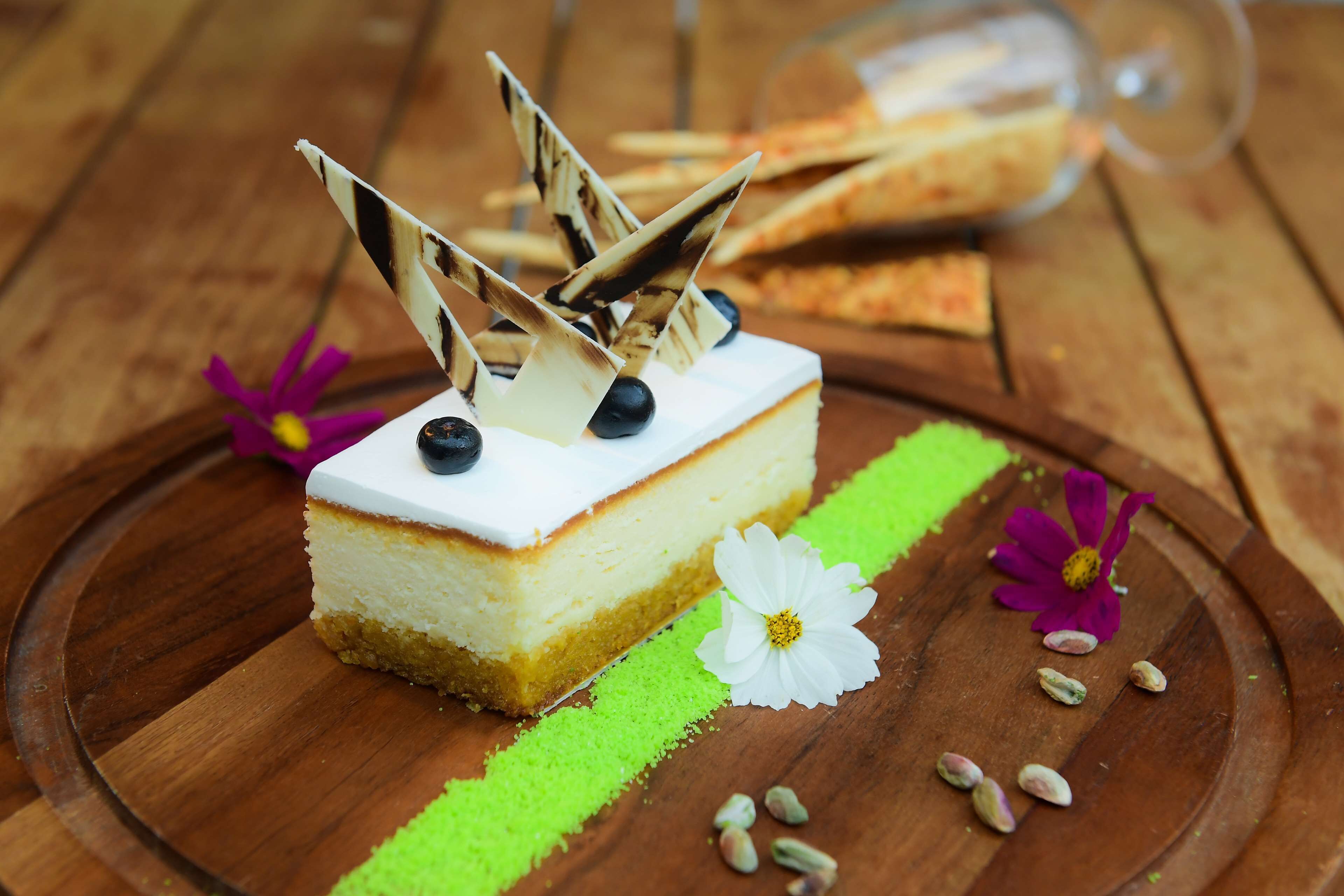 Ein Stück Käsekuchen auf einem Holzboden mit dekorativen Elementen.