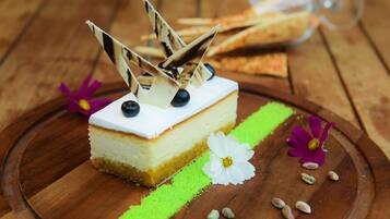 Een stuk cheesecake op een houten plank met decoratieve details.