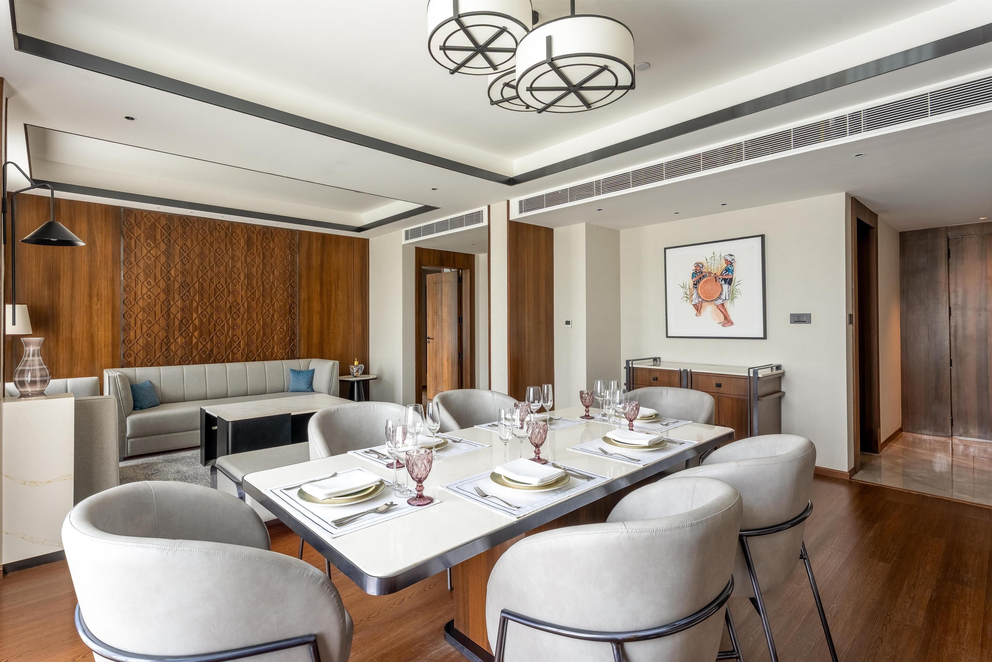A modern dining area with a long table set for six, surrounded by six chairs.