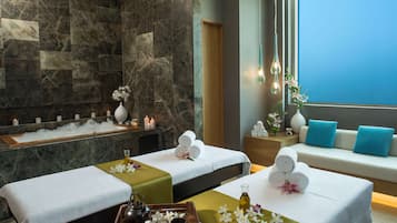 Relax in a serene space with two massage tables, a seating area, and a soothing ambiance.