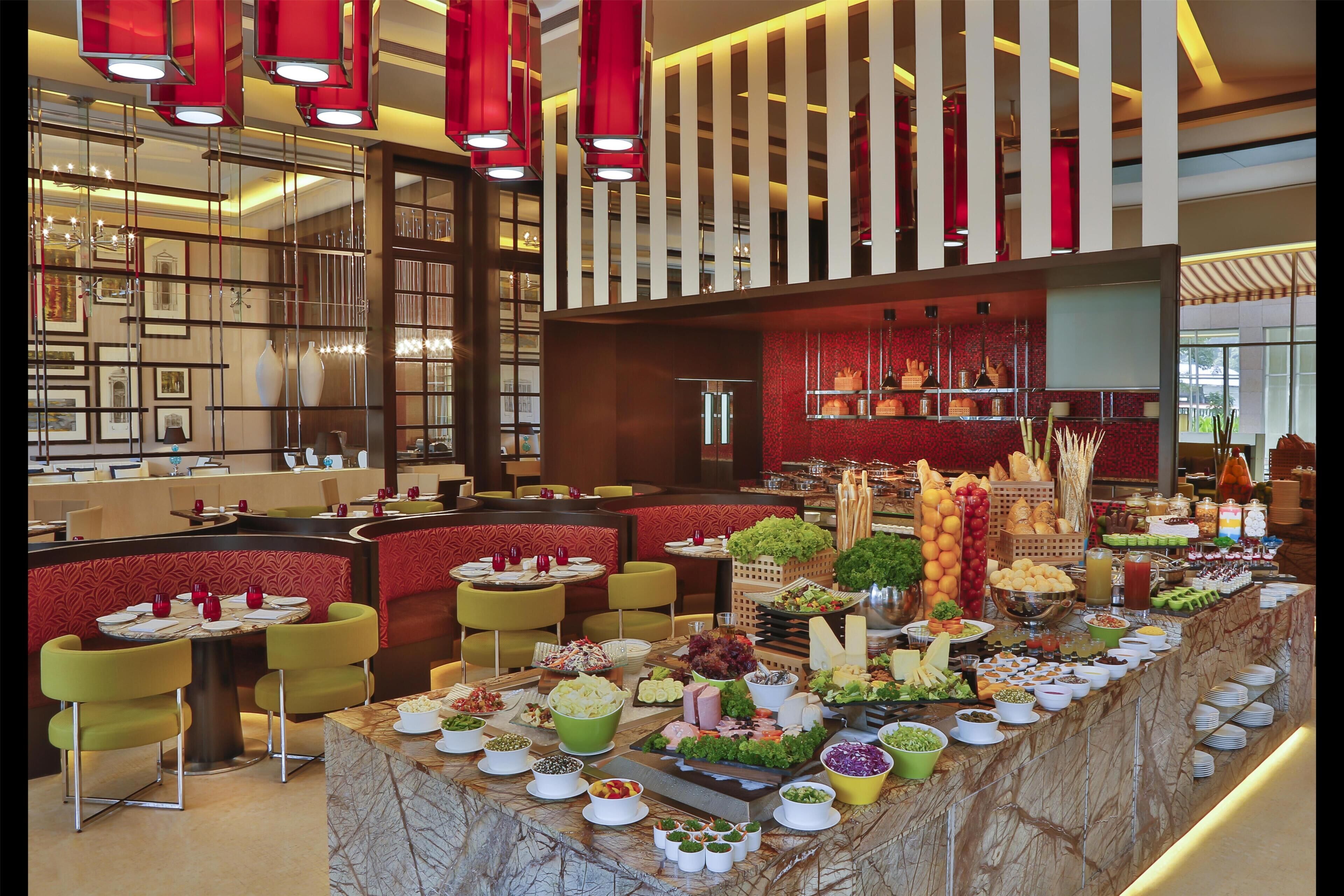 A buffet setup with various food items and a seating area with round tables and chairs.