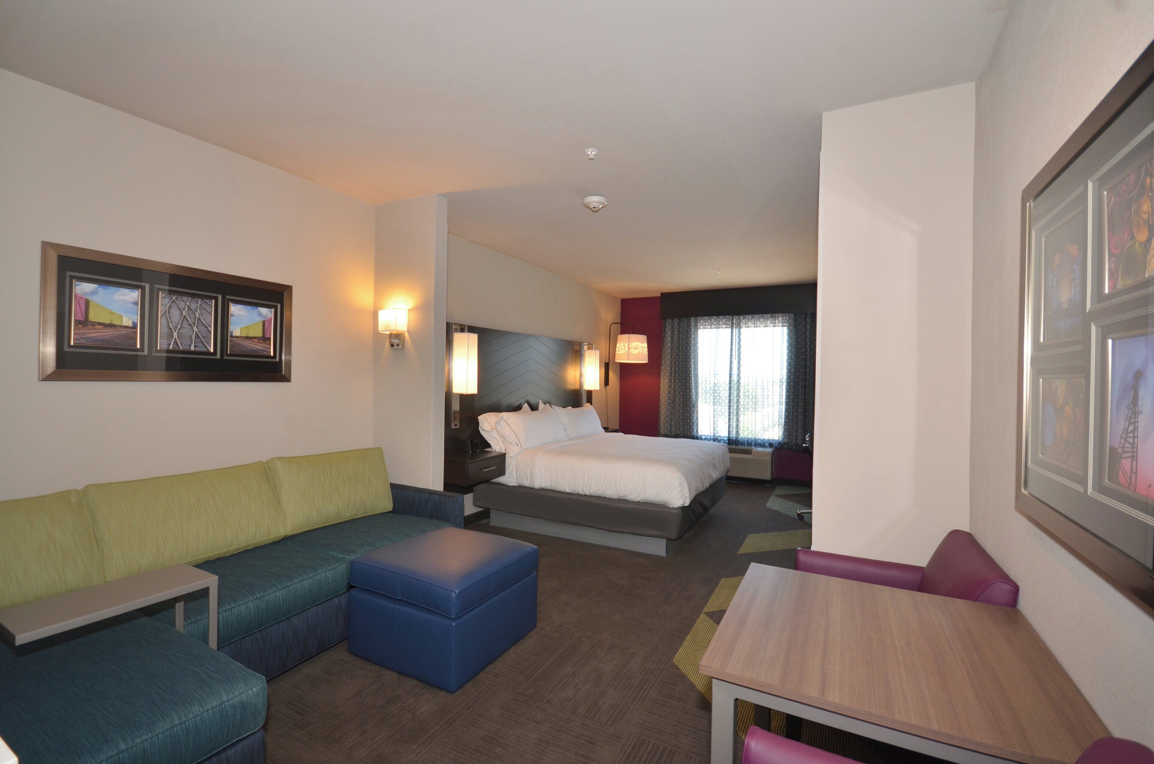Une chambre d’hôtel avec un lit, un canapé, une table et une chaise.