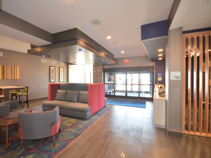 A hotel lobby with a reception desk, seating area, and a view of the entrance.