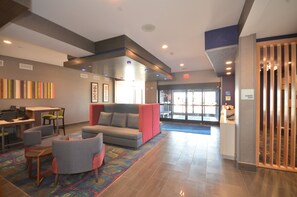 A hotel lobby with a reception desk, seating area, and a view of the entrance. - Holiday Inn Express & Suites Oklahoma City Mid - Arpt Area by IHG (Oklahoma City)