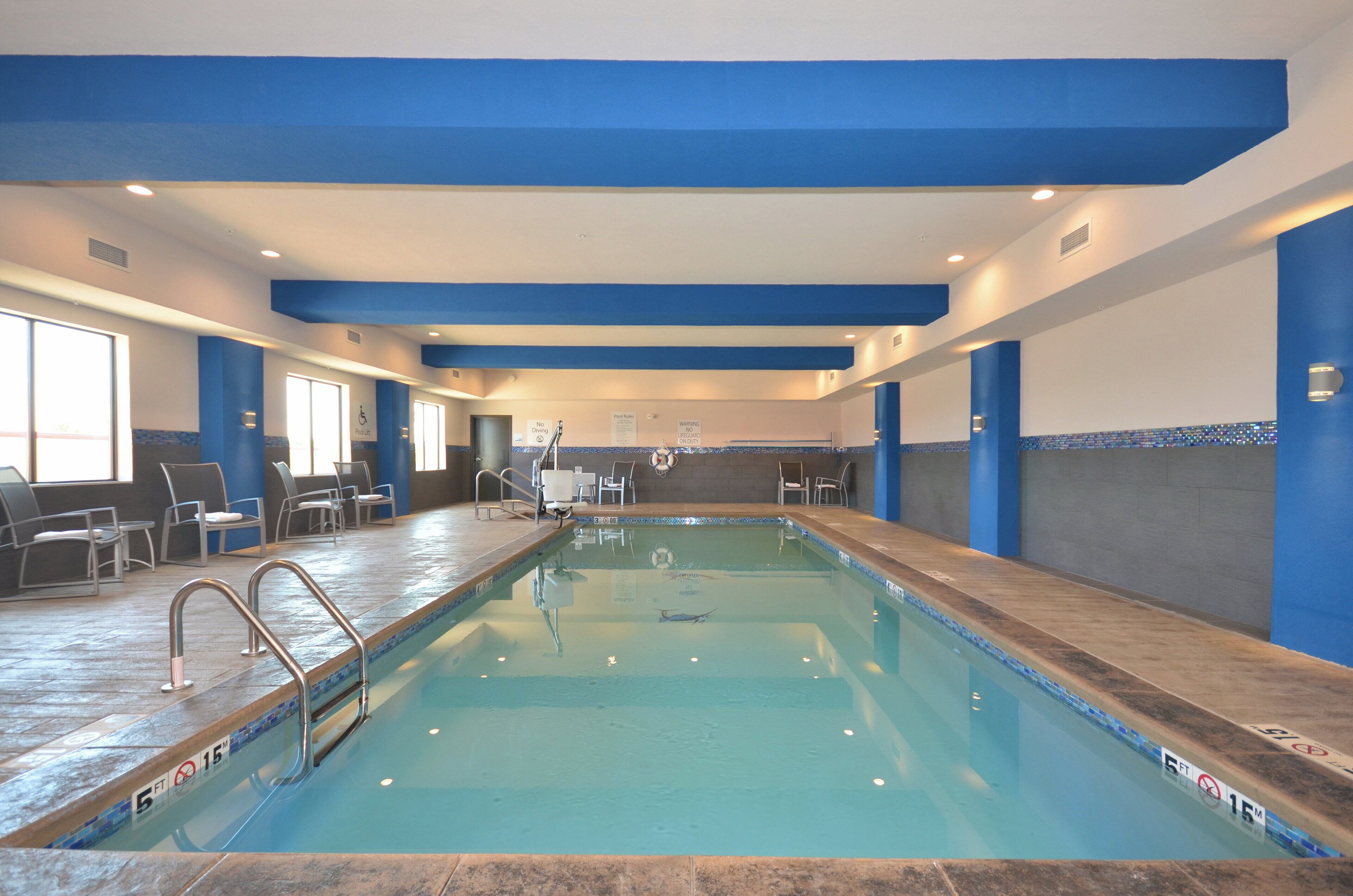 Una piscina techada, sillones reclinables de piscina