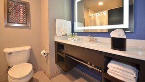 A bathroom with a toilet, sink, and mirror. - Holiday Inn Express & Suites Oklahoma City Mid - Arpt Area by IHG (Oklahoma City)