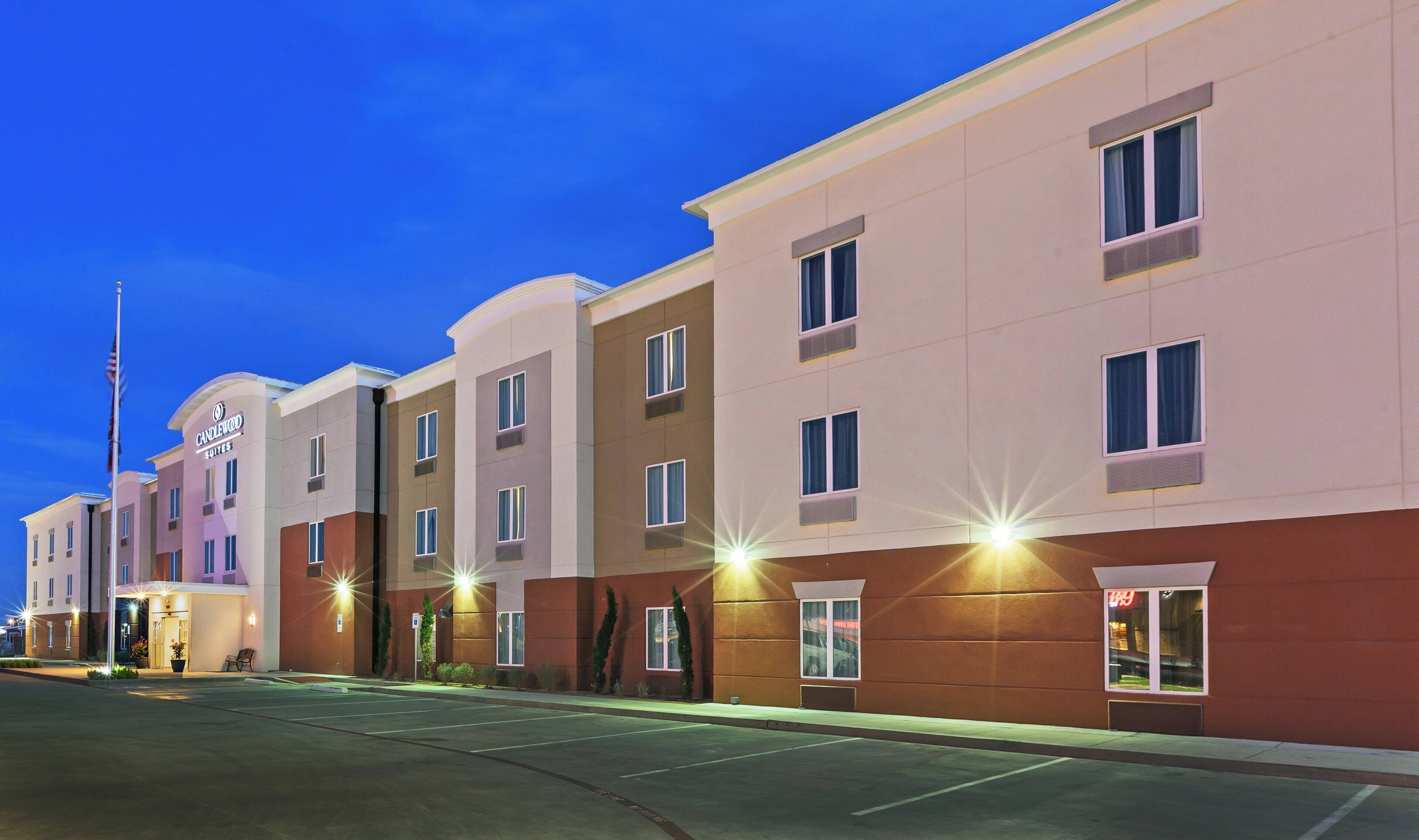 A multi-story hotel with a flat facade, evenly spaced windows, and a clear sky.