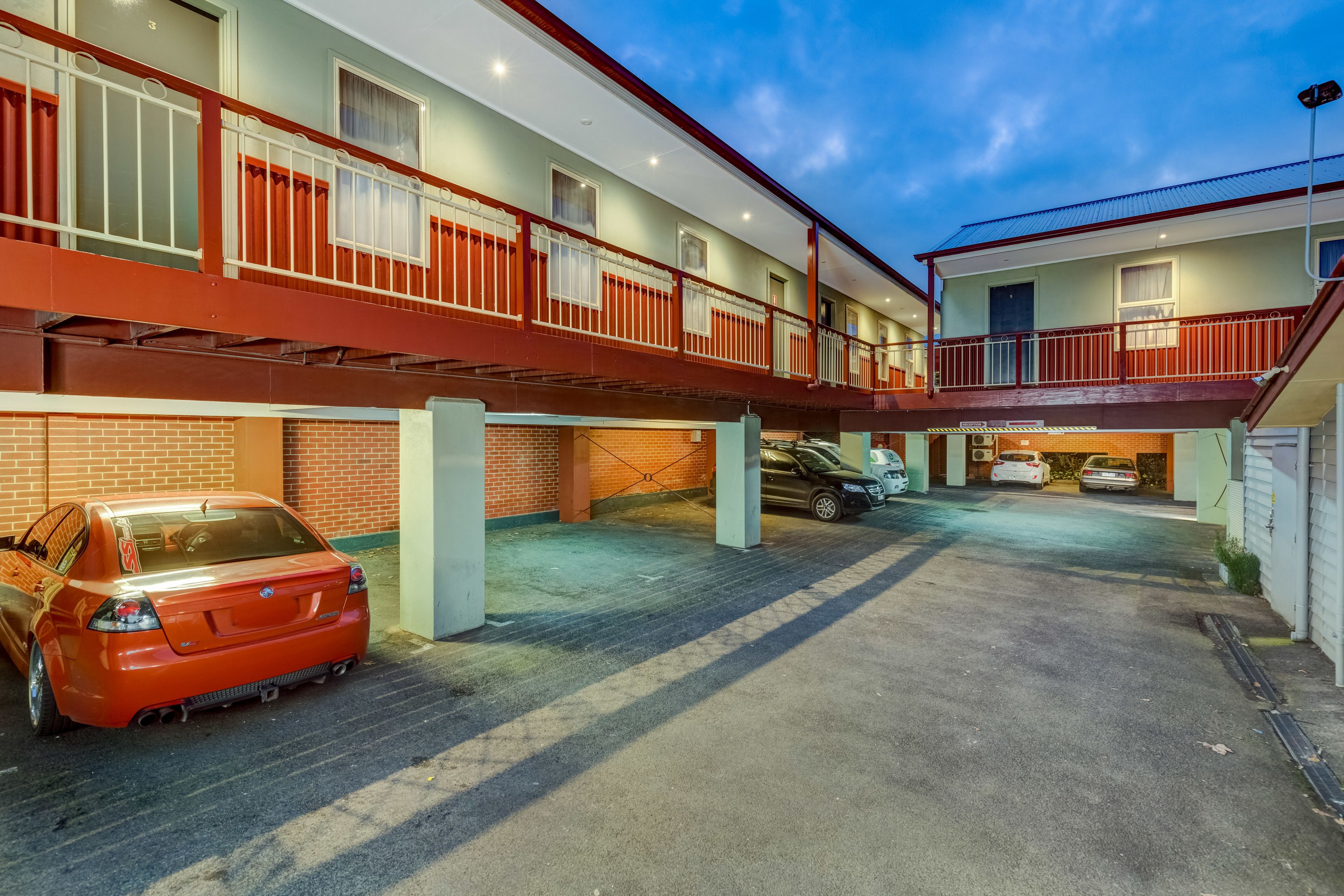 A multi-story parking garage with cars parked on the ground floor.