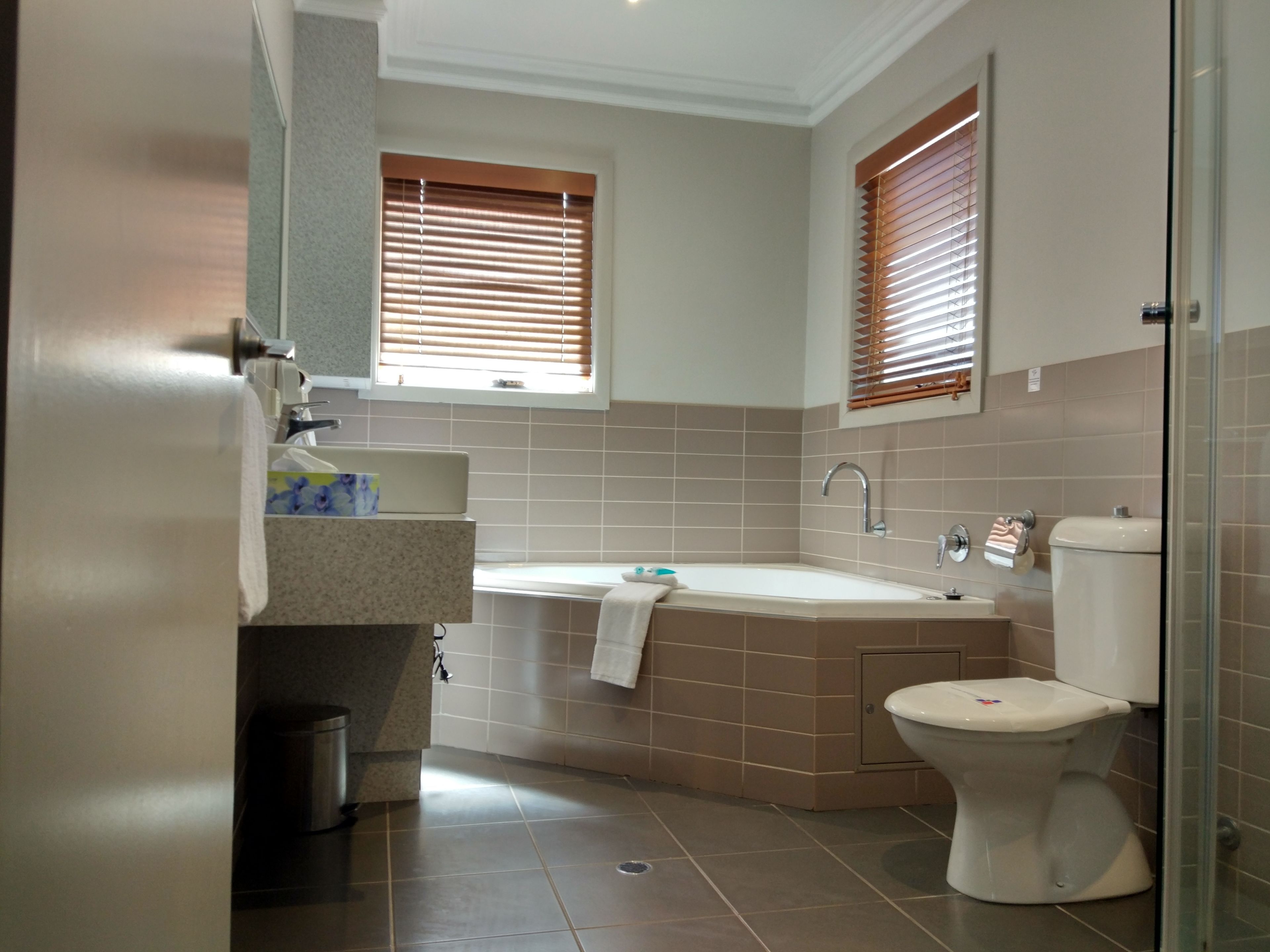 A modern bathroom with a bathtub, toilet, and sink.