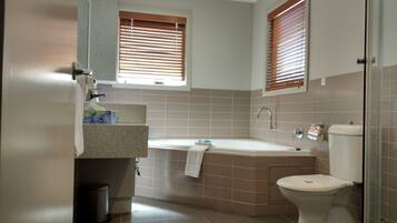 A modern bathroom with a bathtub, toilet, and sink.