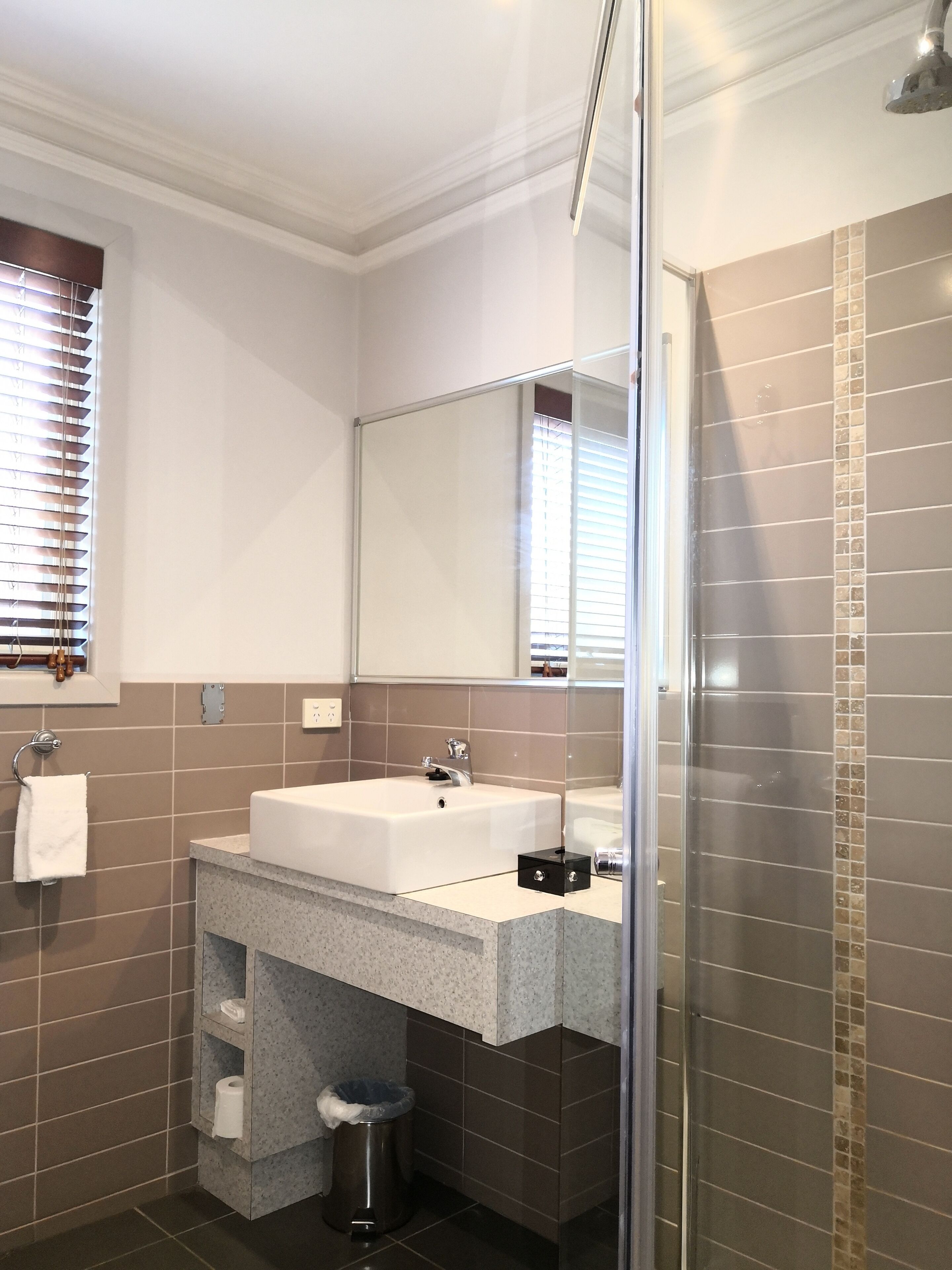 Un bany modern amb un mirall gran, un lavabo i una dutxa.