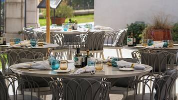 Un espace de restauration en plein air avec des tables et des chaises rondes, des parasols et une enseigne sur laquelle on peut lire « ROYAL ».