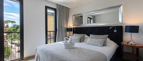 Deluxe dubbelrum eller tvåbäddsrum - utsikt mot trädgården | Minibar, värdeförvaringsskåp på rummet, skrivbord och barnsängar