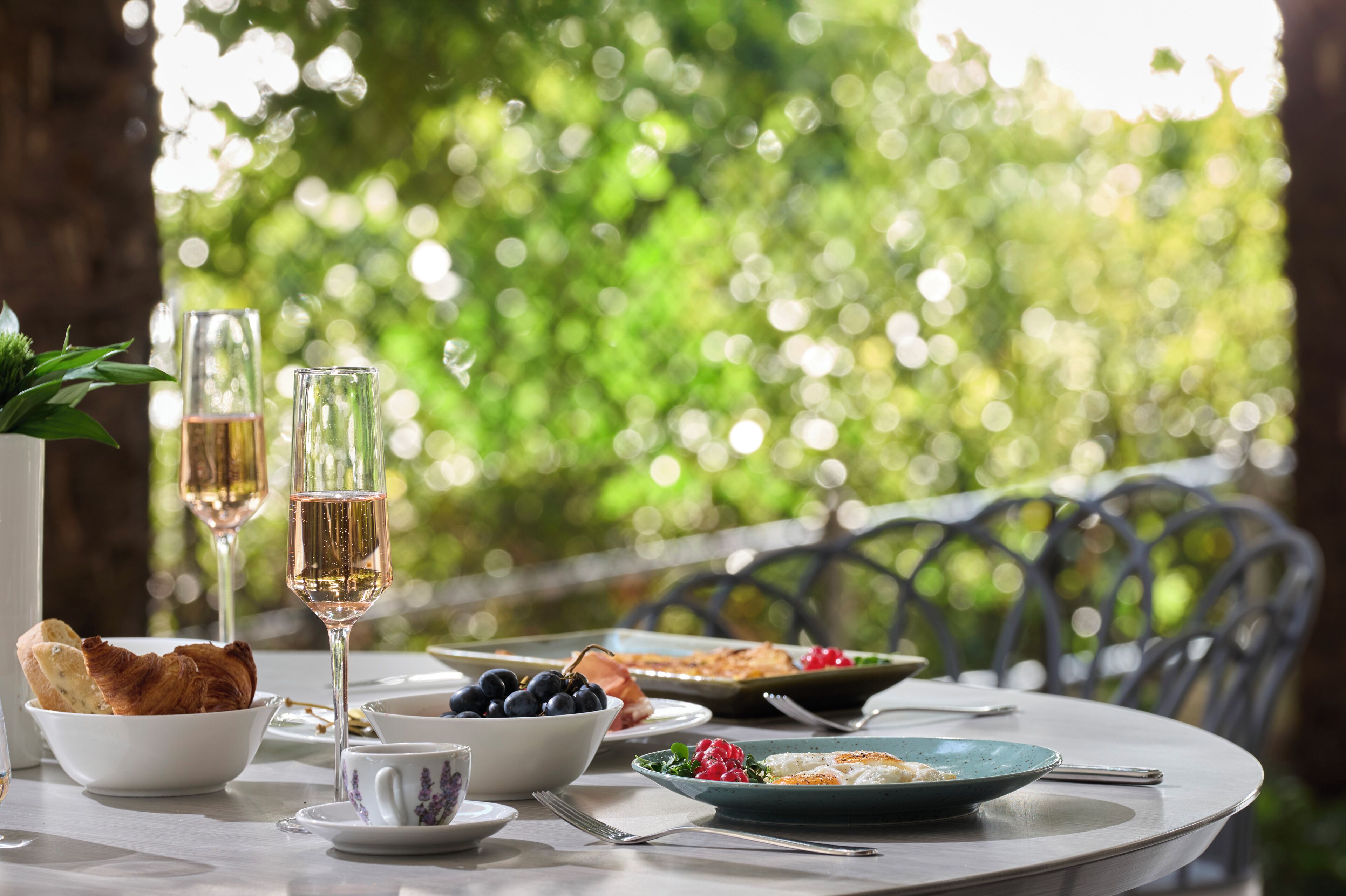 Ein Tisch, gedeckt für eine Mahlzeit, mit Grün im Hintergrund.