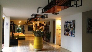 A spacious lobby with a tiled floor, a large yellow planter, and a staircase with geometric railings. - Keeree Ele Resort (Ko Chang)