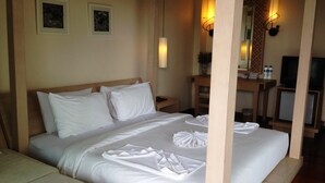 A hotel room with a large bed, a bedside table, a mirror, a television, and a small refrigerator. - Keeree Ele Resort (Ko Chang)