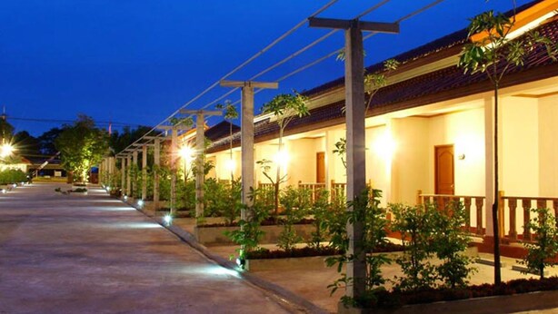 A row of hotel rooms with individual balconies, a concrete pathway, and outdoor lighting. - Oasis Resort (Krabi)