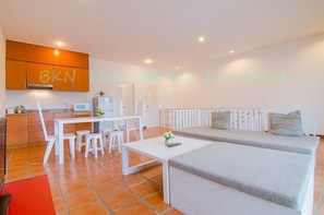 A modern apartment with a kitchenette, a dining area, and a living space with a sofa and a coffee table.