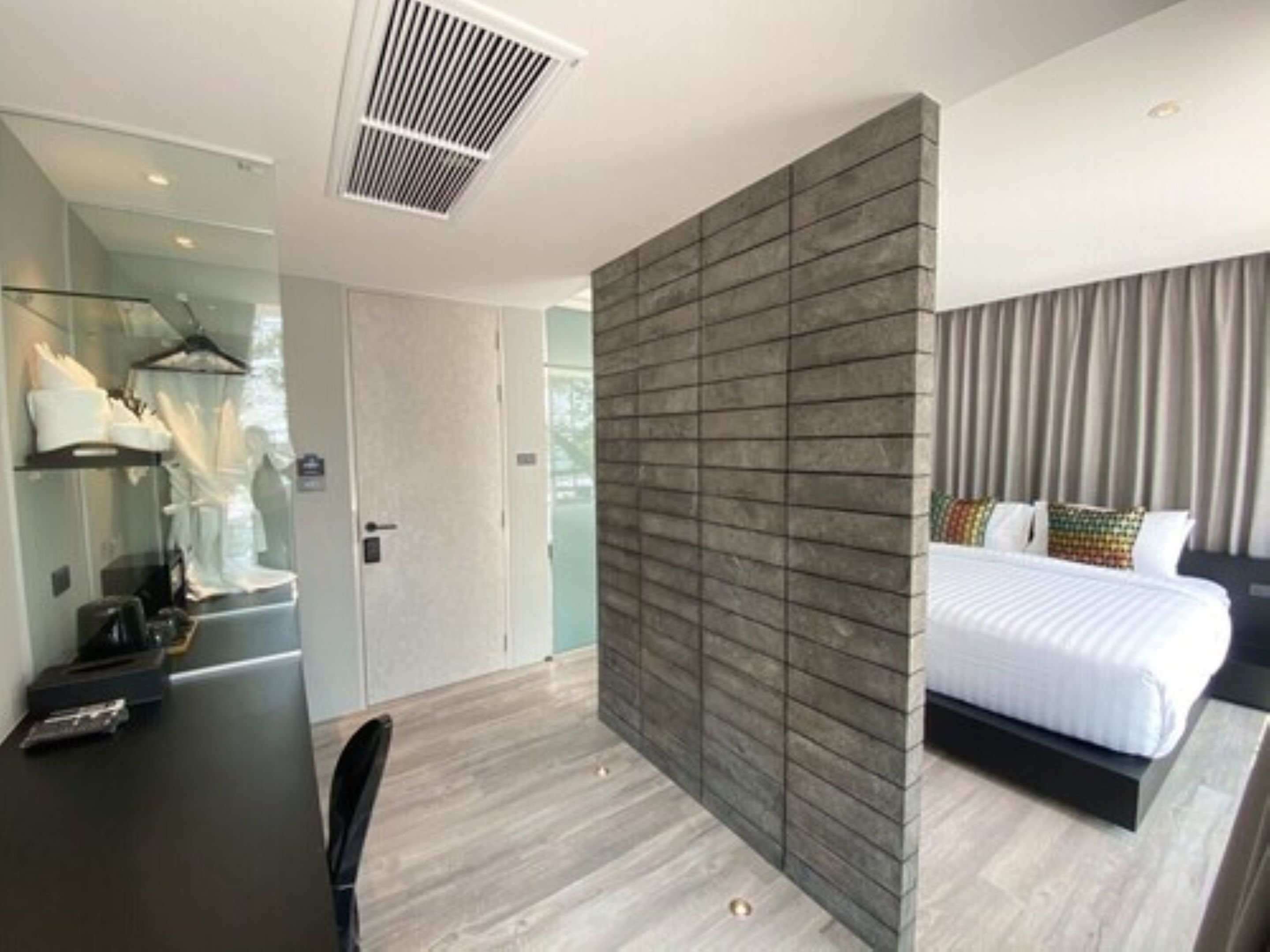 Een moderne hotelkamer met een groot bed, een bureau en een kledingkast.