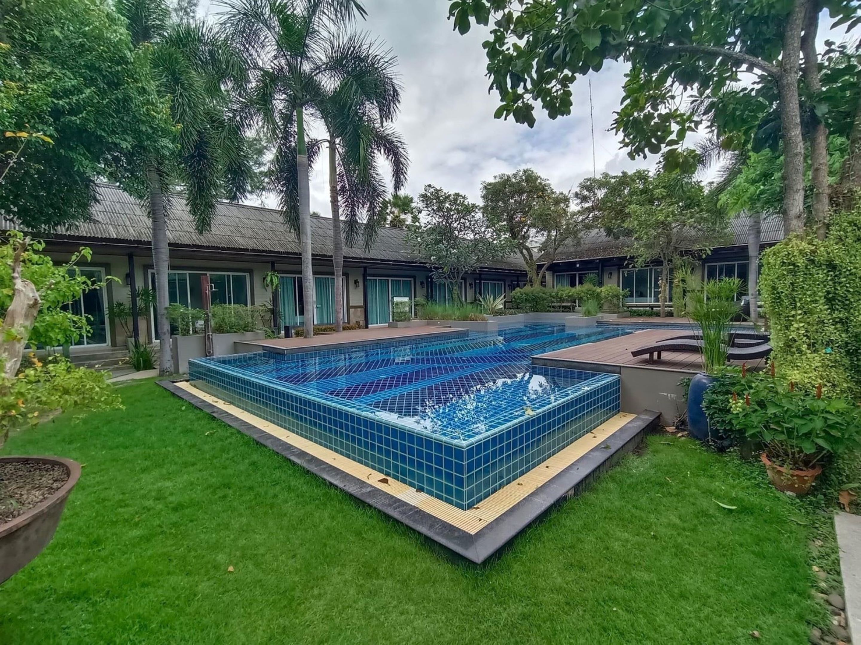 Una piscina rodeada de exuberante vegetación y edificios modernos.