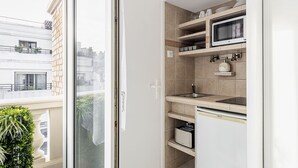 A modern kitchen with a microwave, oven, and built-in dishwasher. - Résidence Courcelle (Levallois-Perret)