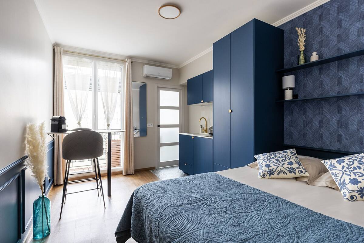 Un dormitorio con cama, escritorio y armario.
