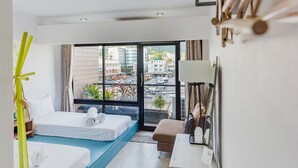 Una habitación de hotel moderna con un ventanal grande, una cama, un sofá y un escritorio.