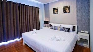 A hotel room with a large bed, a nightstand, a lamp, and two wall art pieces. - I Style Hua Hin Hotel (Hua Hin)