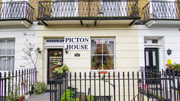 A building with a sign reading "Mandalay Picton House Hotel" at the entrance.