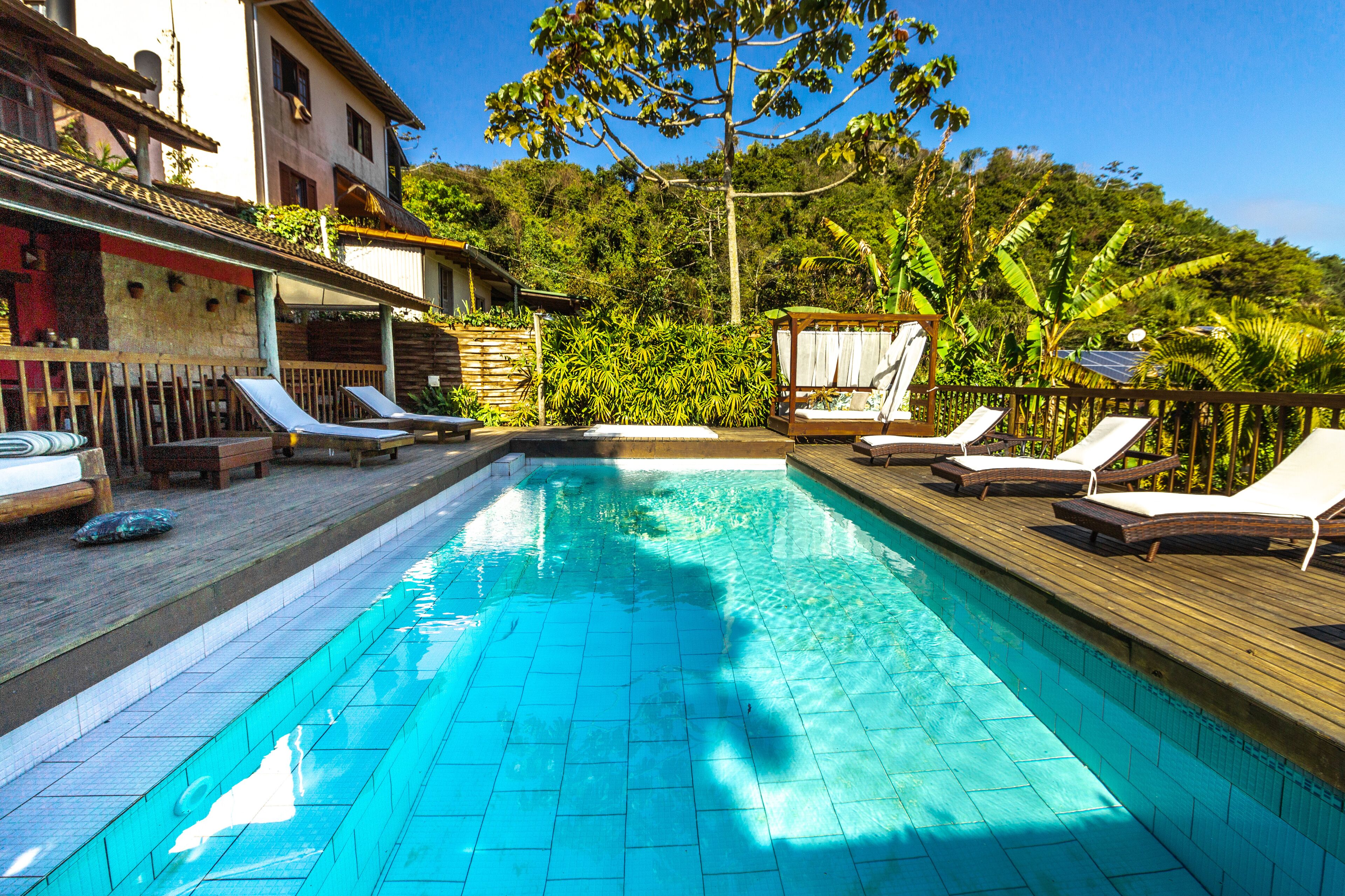 A swimming pool with lounge chairs and a wooden deck.