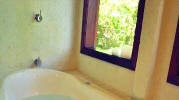 Una bañera con adornos florales y una vela.