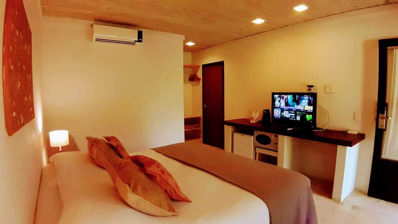 Une chambre d’hôtel équipée d’un lit, d’un bureau avec une télévision et d’un appareil de climatisation.