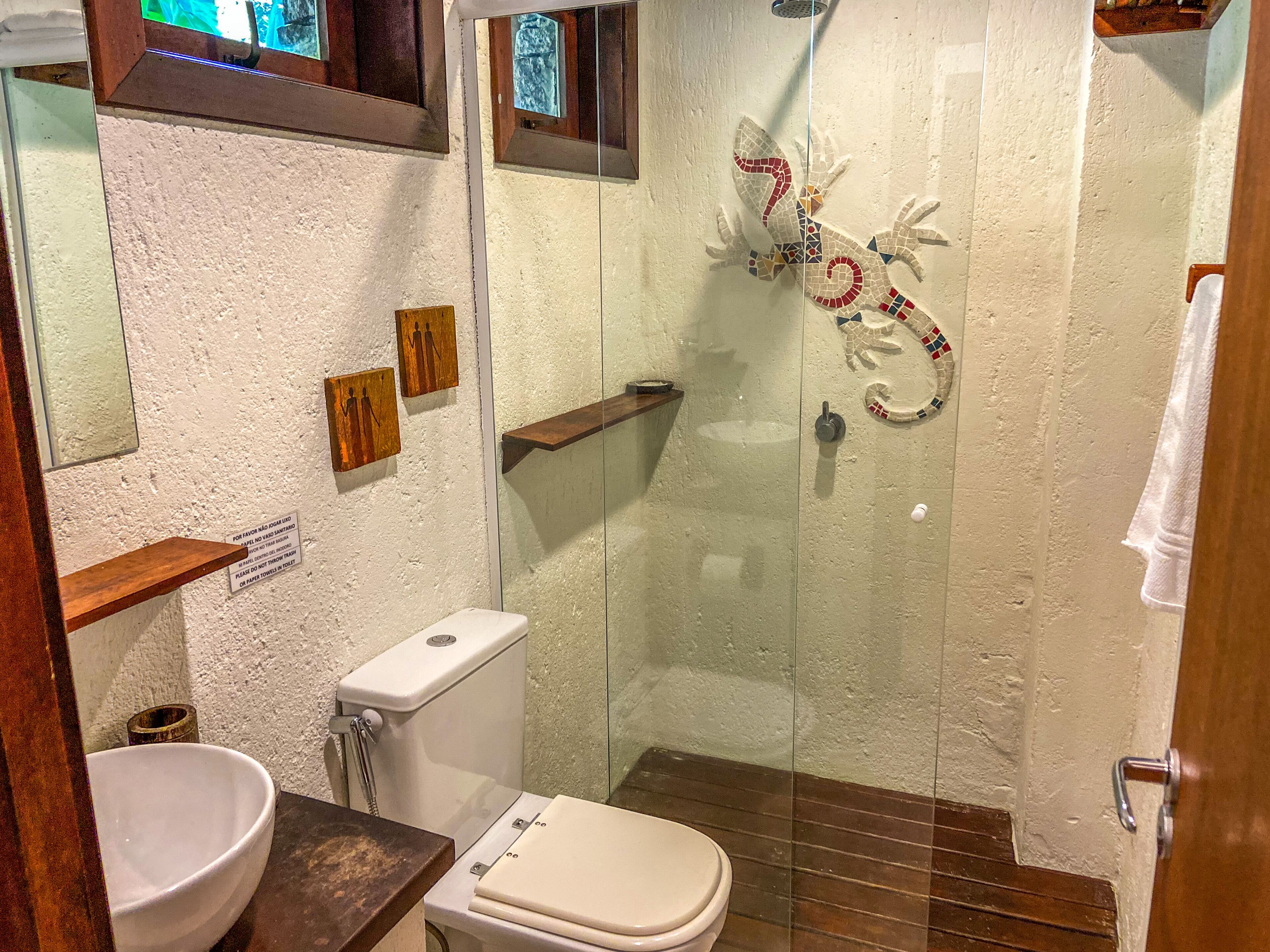 A bathroom with a toilet, sink, and shower.