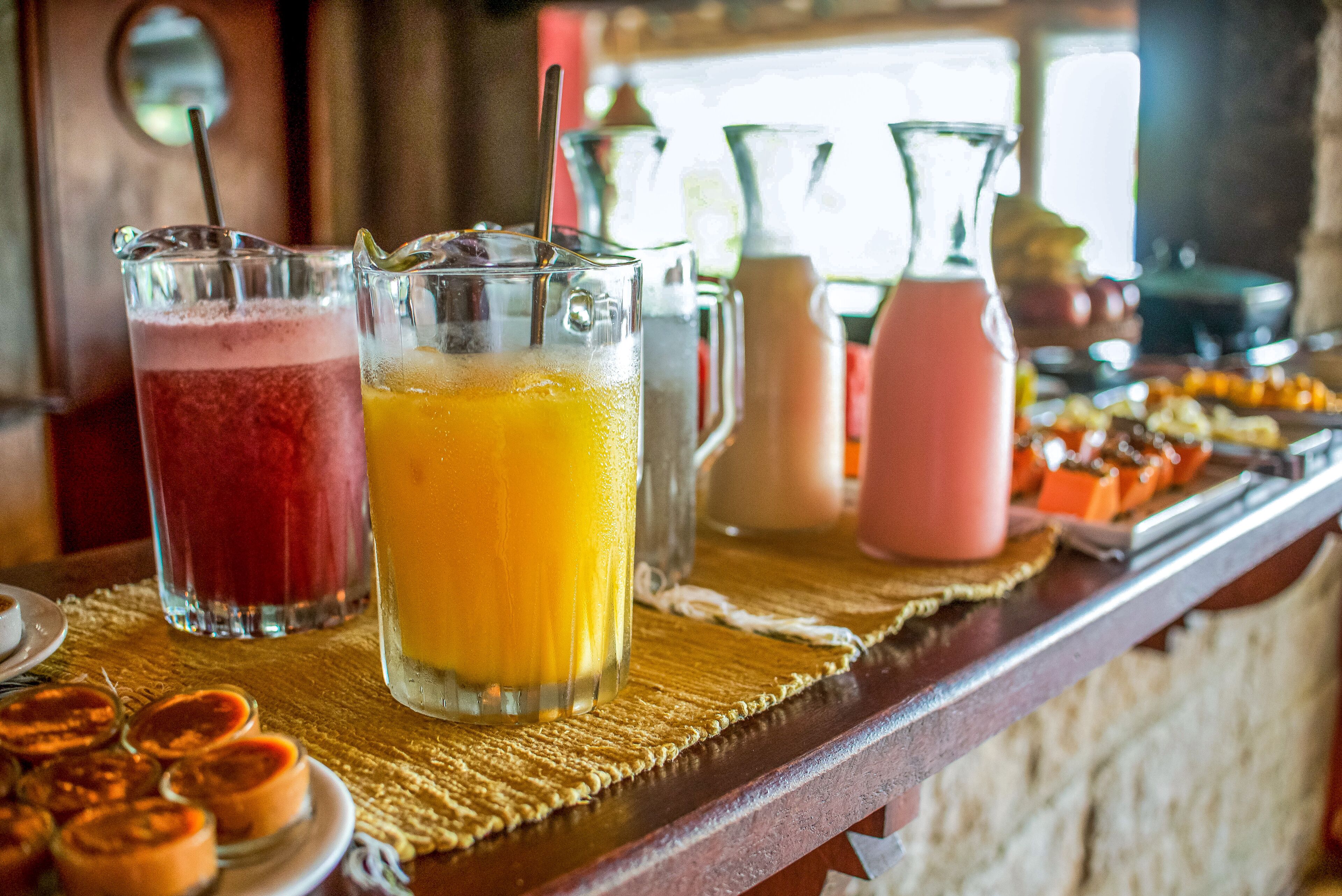 Zona de bar con diversas bebidas y un bufé de pasteles.