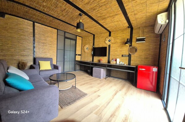 Bungalow Deluxe, vistas al jardín | Zona de estar | Televisión LCD de 32 pulgadas con canales por satélite, una televisión