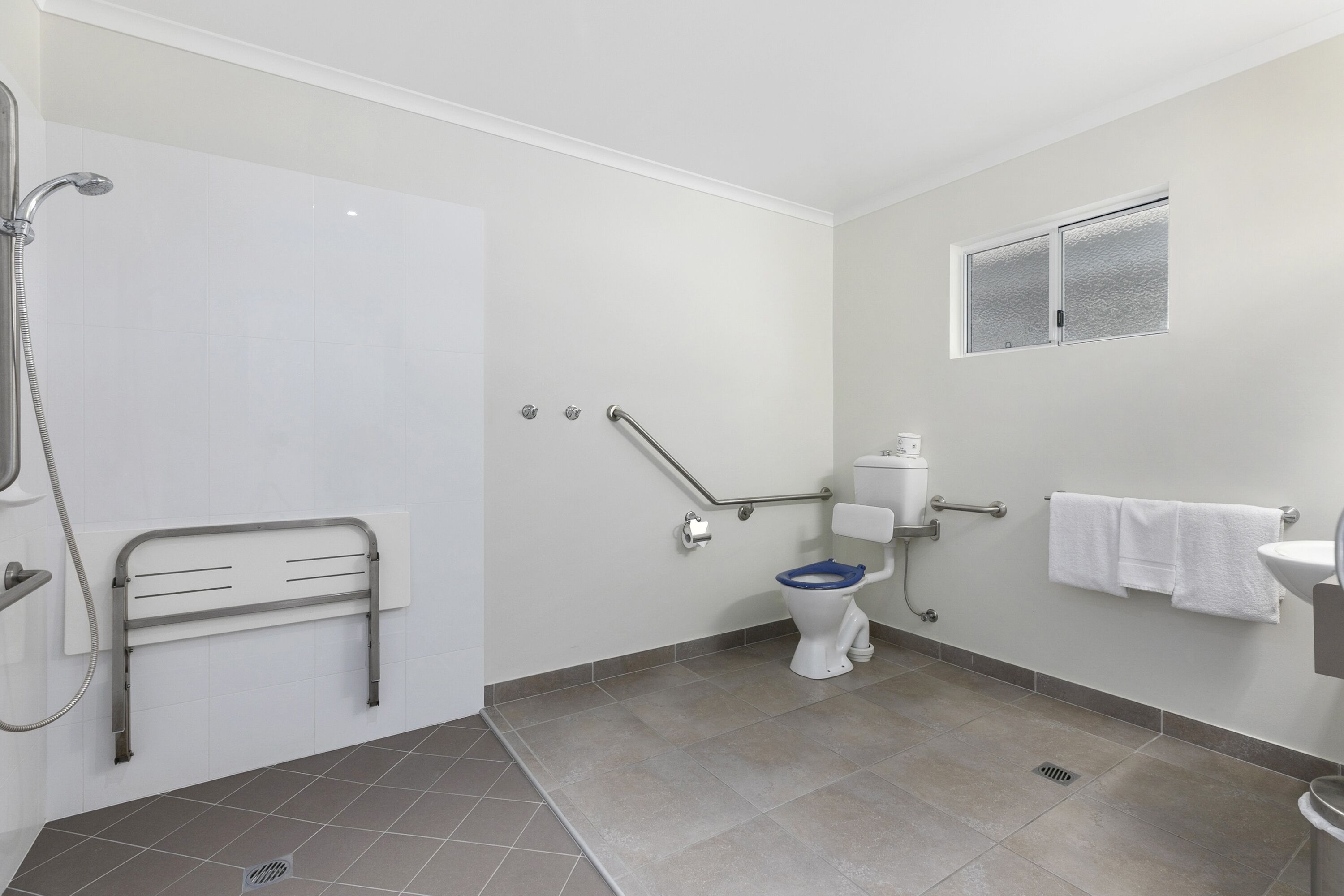 A bathroom with a shower, toilet, and sink.