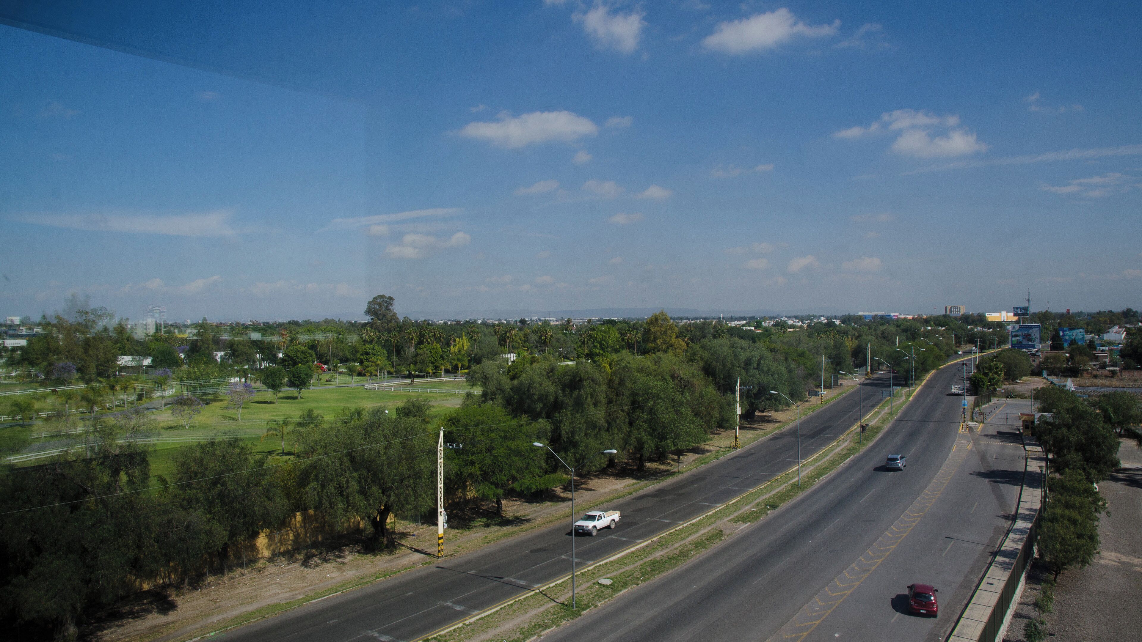 Carretera con varios carriles, vehículos y cielo despejado.