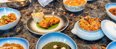 Une variété de plats indiens, notamment du poulet tandoori, du paneer et une sauce verte (chutney).