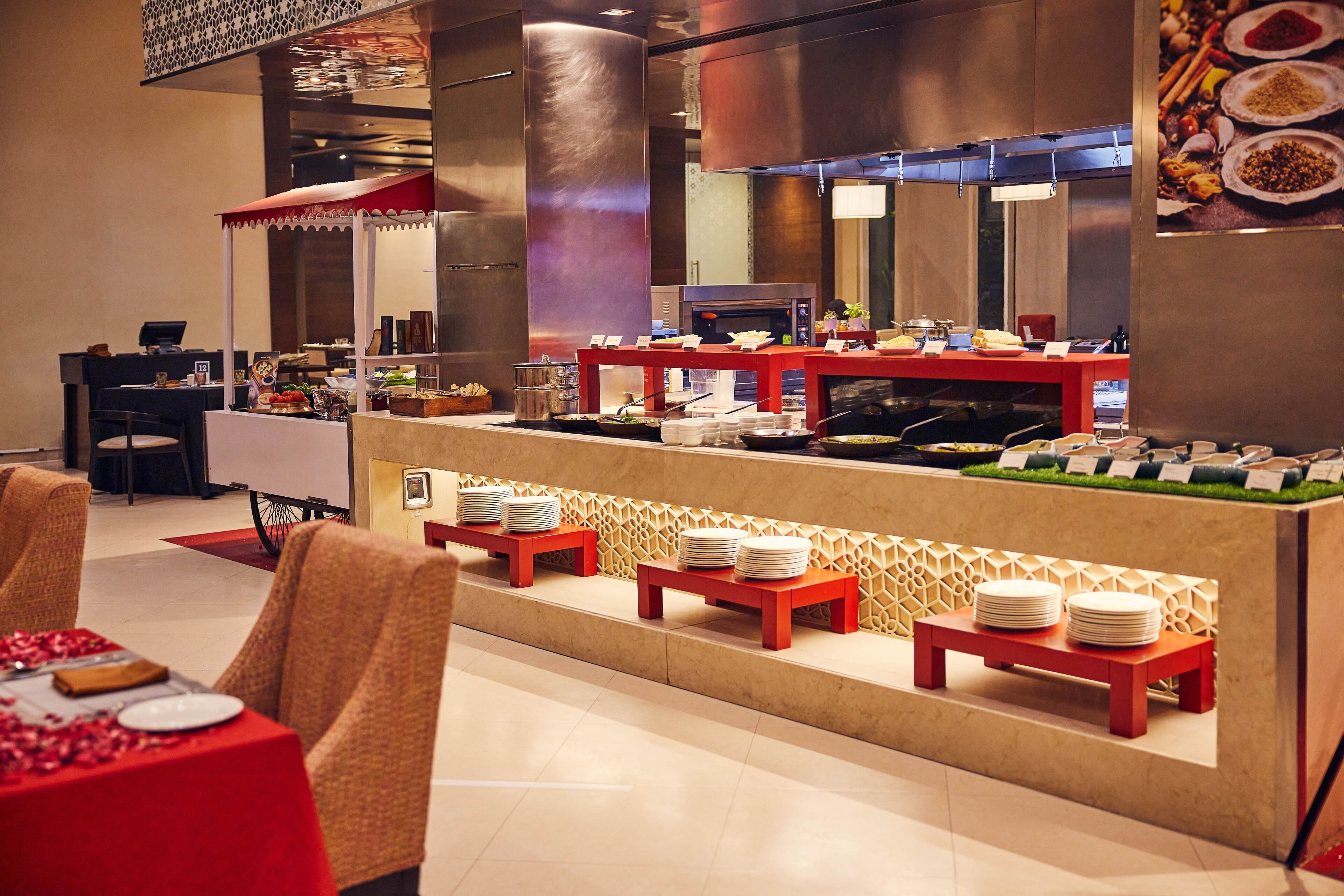 Un buffet avec plusieurs points de service, un espace avec des chaises et un comptoir où sont présentés les plats.