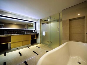 Un baño moderno con cabina de ducha de vidrio, bañera independiente y tocador con encimera de mármol.