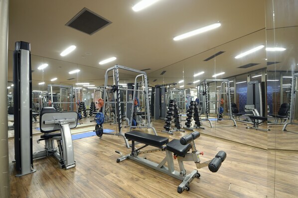 A gym with various exercise equipment, mirrored walls, and a wooden floor. - La Blanche Island Bodrum - All Inclusive (Milas)