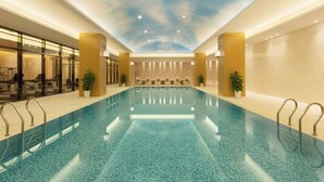A large indoor swimming pool with a ceiling mural, seating area, and potted plants. - Wyndham Chongqing Yuelai (Chongqing)