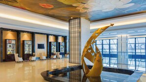 A modern lobby with a central water feature, seating area, and a large window providing natural light. - Wyndham Chongqing Yuelai (Chongqing)