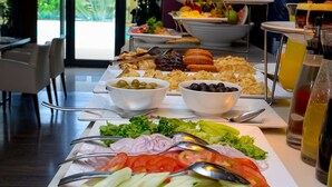 A buffet table with various food items and utensils. - Fiesta Residences Boutique Hotel and Serviced Apartments (Accra)